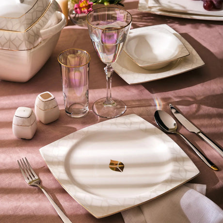 Emsan Fine Bone Leaf white and gold dinnerware set with glassware and silver flatware on mauve tablecloth